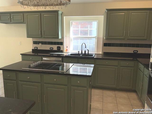 kitchen with tasteful backsplash, sink, and light tile patterned floors