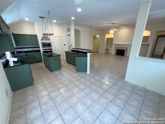 kitchen with a kitchen island, decorative columns, sink, ceiling fan, and stainless steel appliances