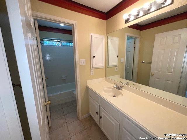 bathroom with shower / tub combination, vanity, tile patterned flooring, and ornamental molding