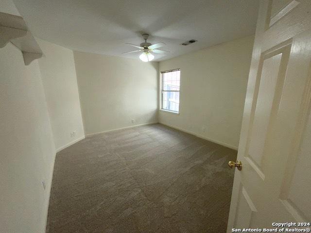 carpeted spare room with ceiling fan