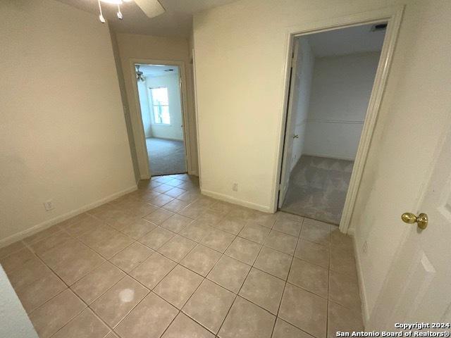 tiled spare room with ceiling fan