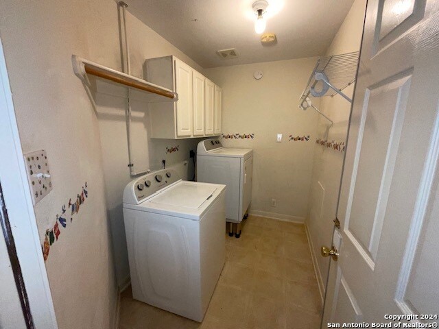 laundry room with cabinets and washer and dryer