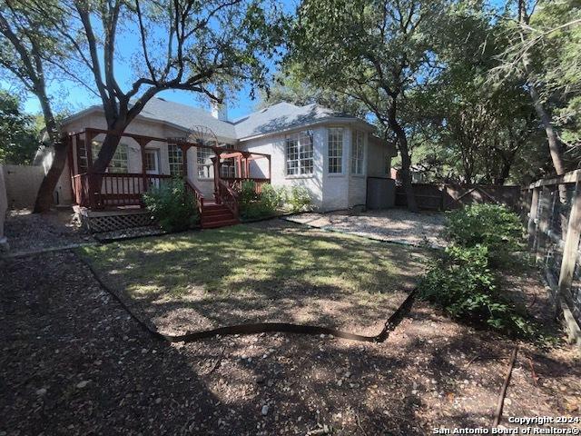 back of property featuring a yard and a deck