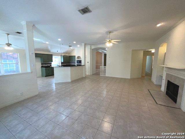 unfurnished living room featuring light tile patterned floors and ceiling fan