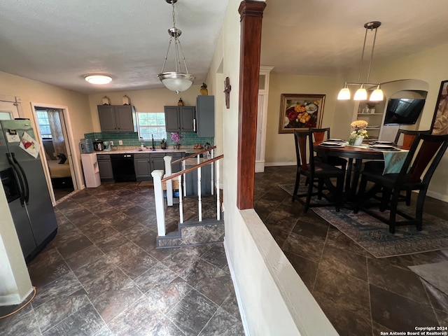 kitchen with decorative light fixtures, gray cabinets, stainless steel refrigerator with ice dispenser, black dishwasher, and decorative backsplash