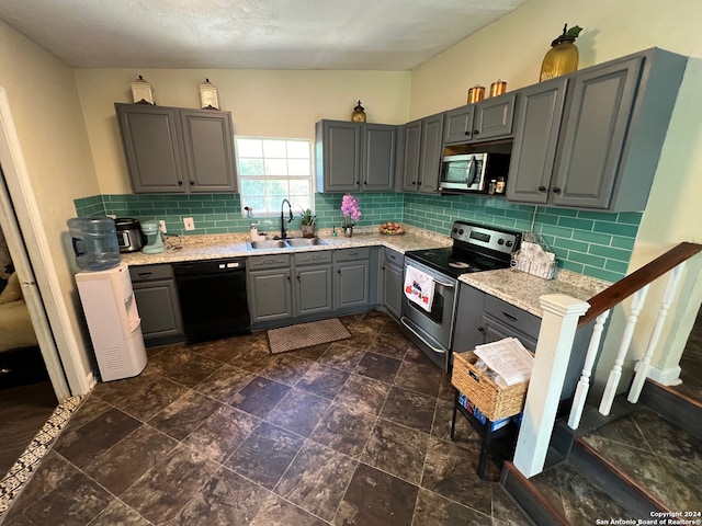 kitchen with gray cabinets, backsplash, sink, and stainless steel appliances