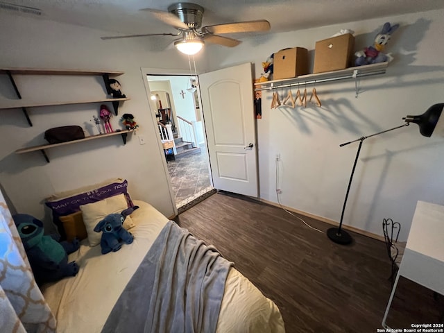 bedroom with dark hardwood / wood-style flooring and ceiling fan