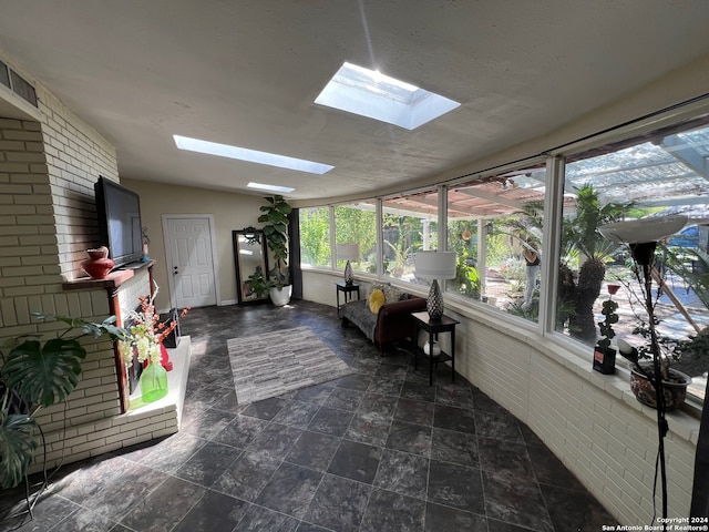 sunroom featuring lofted ceiling with skylight