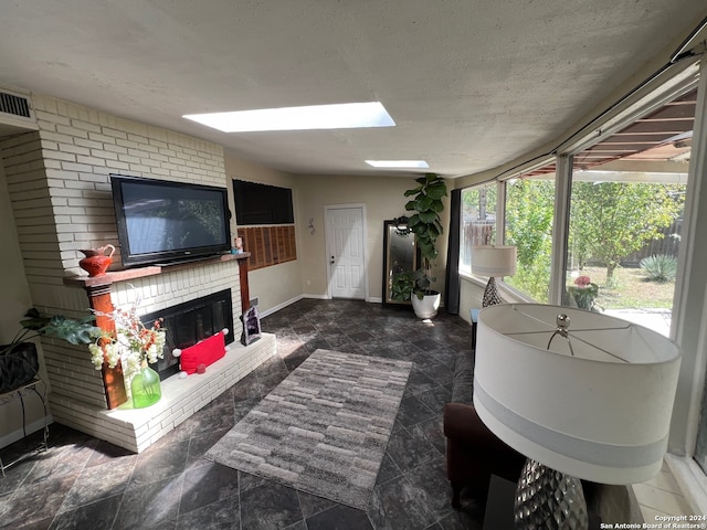 sunroom / solarium with vaulted ceiling with skylight and a fireplace