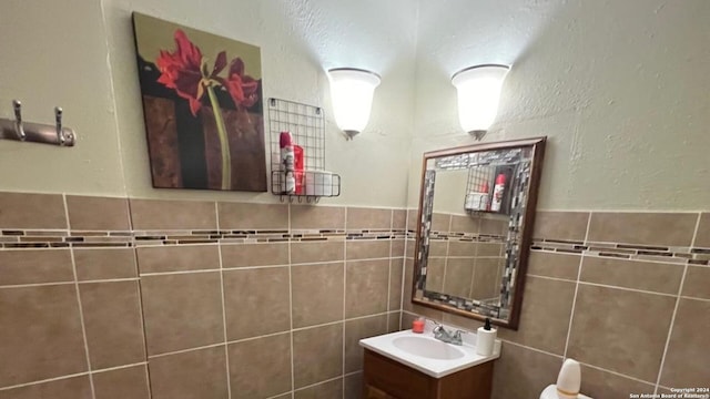 bathroom with vanity and tile walls