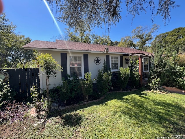 single story home with a pergola and a front yard