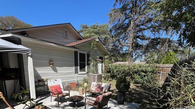 view of property exterior with a patio and an outdoor fire pit