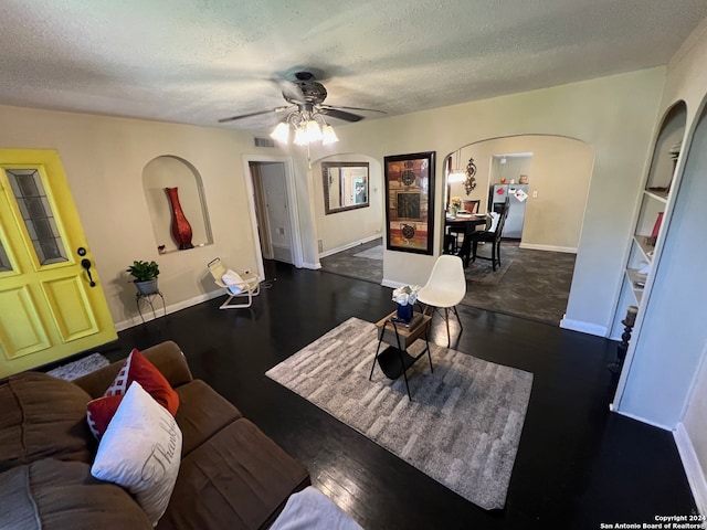 interior space featuring ceiling fan, dark hardwood / wood-style floors, and a textured ceiling