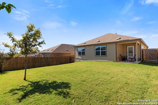 back of property with a lawn and a patio area