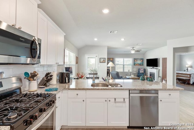 kitchen with stainless steel appliances, kitchen peninsula, and a healthy amount of sunlight