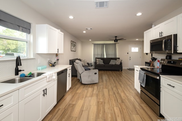 kitchen with ceiling fan, white cabinets, sink, light hardwood / wood-style flooring, and stainless steel appliances