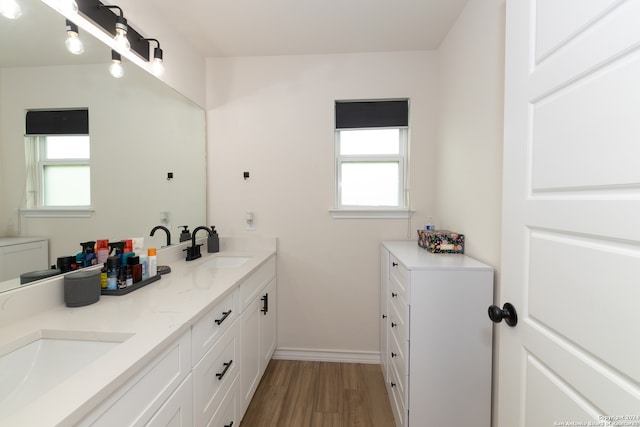 bathroom with vanity, hardwood / wood-style flooring, and a healthy amount of sunlight