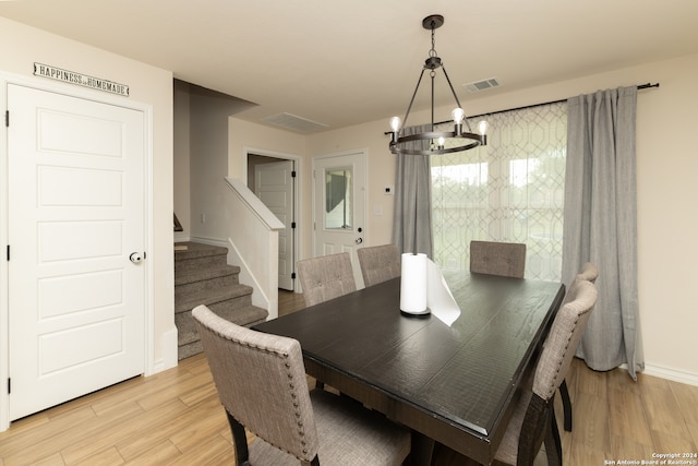 dining space featuring a notable chandelier and light hardwood / wood-style floors