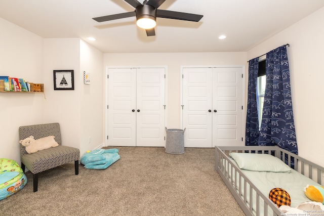 bedroom with ceiling fan, multiple closets, and carpet floors