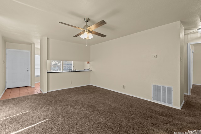 unfurnished living room featuring ceiling fan and light carpet