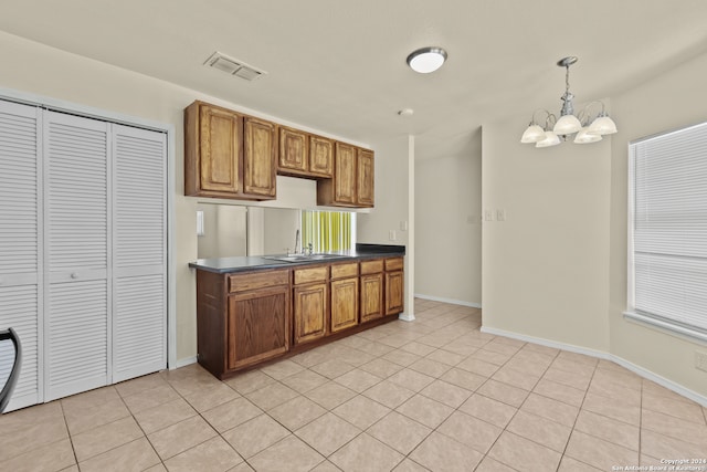 kitchen featuring a notable chandelier, light tile patterned flooring, sink, and decorative light fixtures