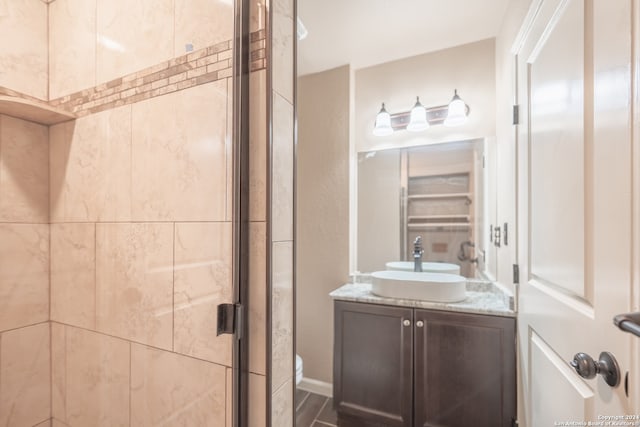 bathroom with walk in shower, vanity, and toilet