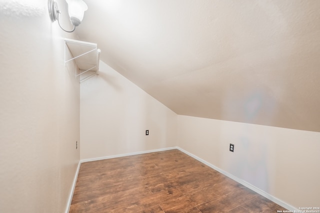 additional living space with lofted ceiling and dark hardwood / wood-style floors