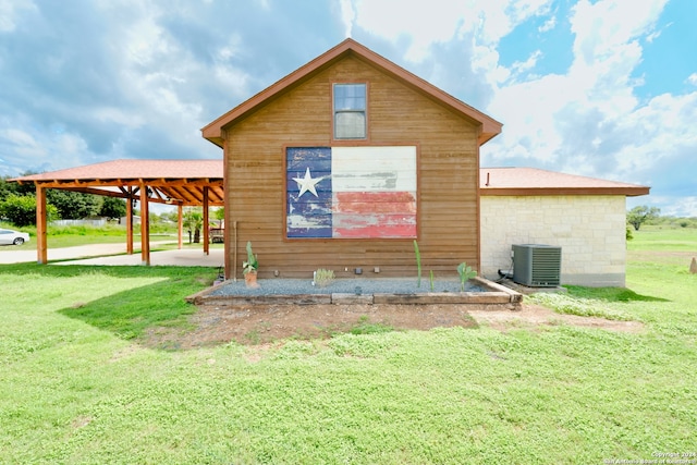 back of property featuring cooling unit, a yard, and a carport