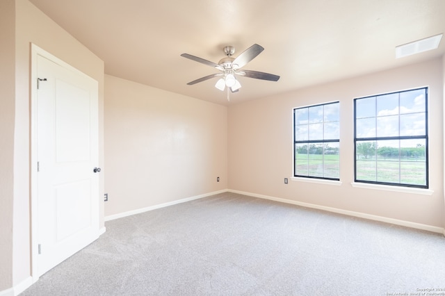 carpeted spare room featuring ceiling fan