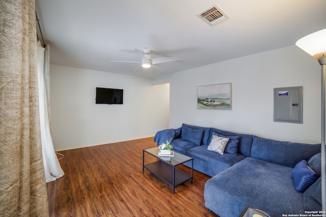 living room featuring ceiling fan, electric panel, and dark wood-type flooring