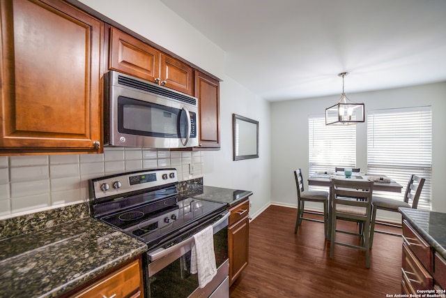 kitchen featuring appliances with stainless steel finishes, hanging light fixtures, tasteful backsplash, dark hardwood / wood-style flooring, and a notable chandelier