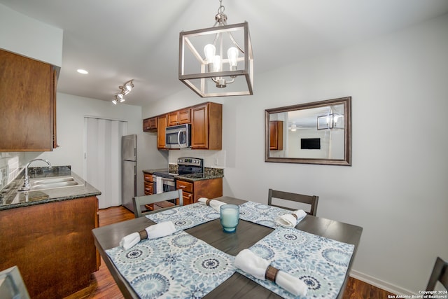 dining room featuring a notable chandelier, dark wood-type flooring, and sink