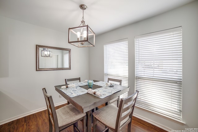 dining room featuring an inviting chandelier and dark wood-type flooring