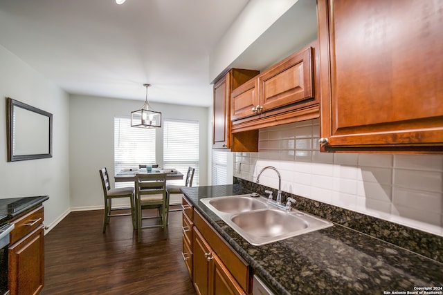 kitchen with dark hardwood / wood-style flooring, backsplash, decorative light fixtures, and sink