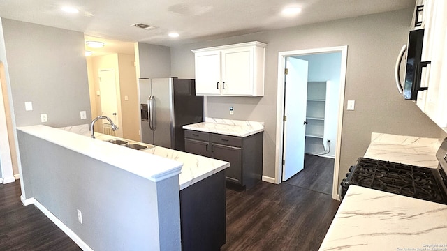 kitchen featuring sink, kitchen peninsula, dark wood-type flooring, white cabinetry, and appliances with stainless steel finishes