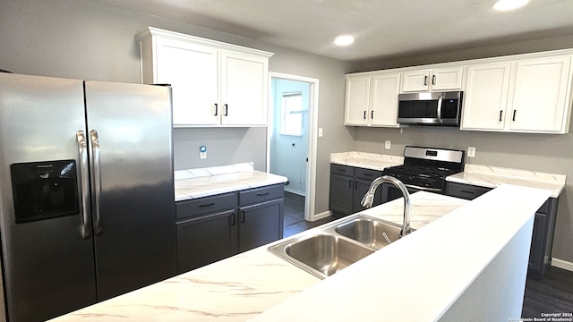 kitchen with white cabinets, appliances with stainless steel finishes, dark wood-type flooring, and sink