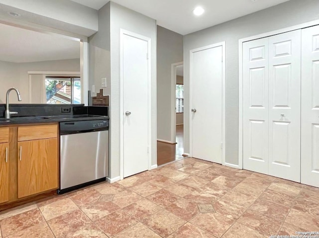 kitchen with stainless steel dishwasher, vaulted ceiling, and sink