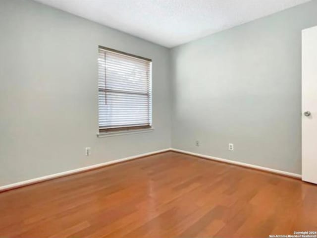 unfurnished room with hardwood / wood-style floors