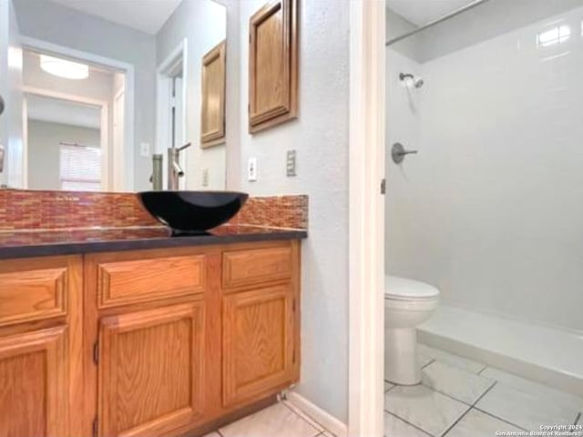 bathroom with tile patterned floors, a shower, vanity, and toilet