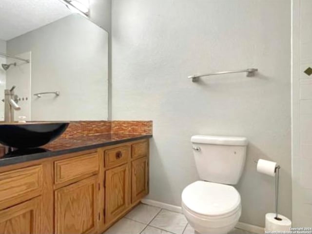 bathroom featuring walk in shower, vanity, tile patterned flooring, and toilet