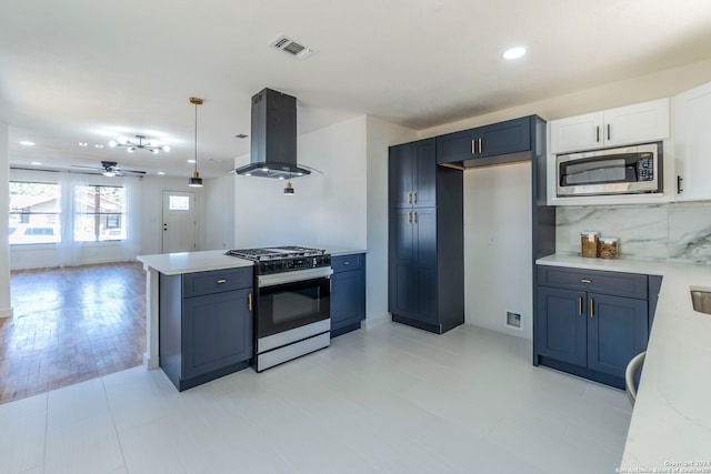 kitchen with light stone counters, hanging light fixtures, island exhaust hood, stainless steel appliances, and decorative backsplash