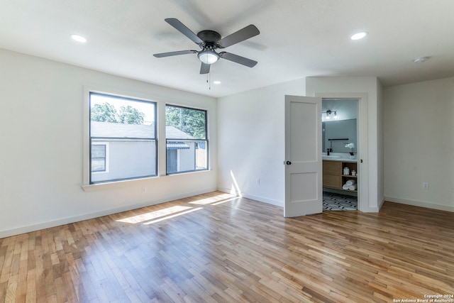 interior space featuring ceiling fan, sink, connected bathroom, and light hardwood / wood-style floors