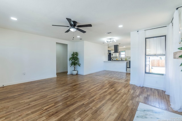 unfurnished living room with ceiling fan and hardwood / wood-style flooring