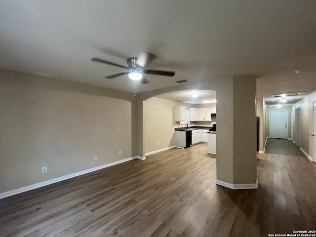 unfurnished living room featuring sink, ceiling fan, and hardwood / wood-style flooring