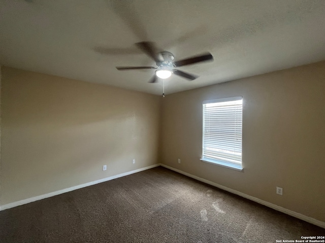 carpeted spare room featuring ceiling fan