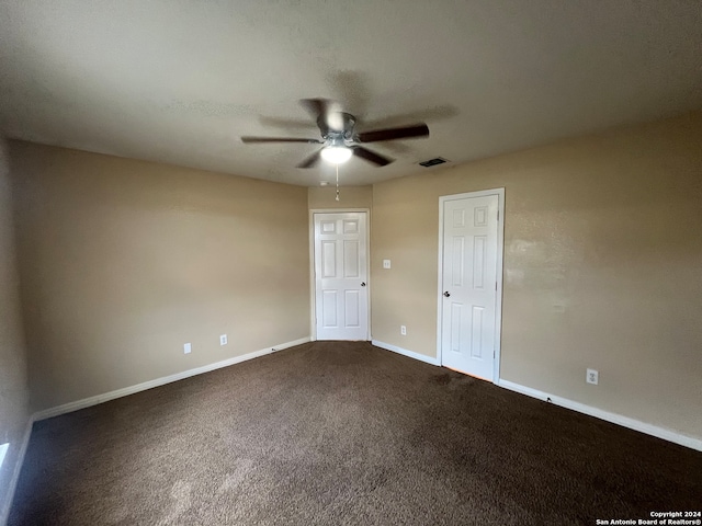 unfurnished room with ceiling fan and carpet