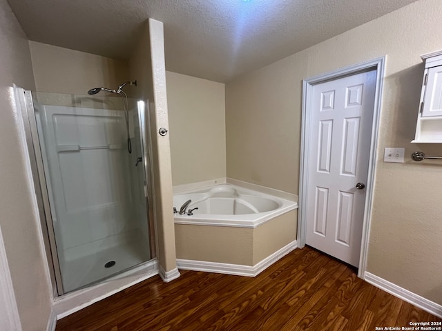 bathroom featuring plus walk in shower, a textured ceiling, and hardwood / wood-style floors