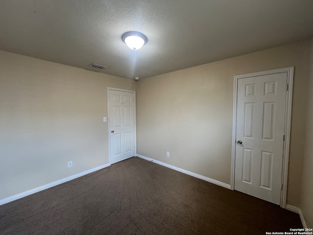 carpeted empty room with a textured ceiling