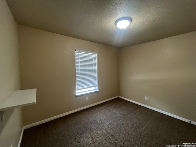 carpeted spare room featuring a textured ceiling