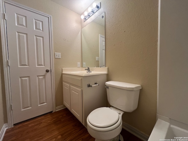 bathroom with wood-type flooring, vanity, and toilet